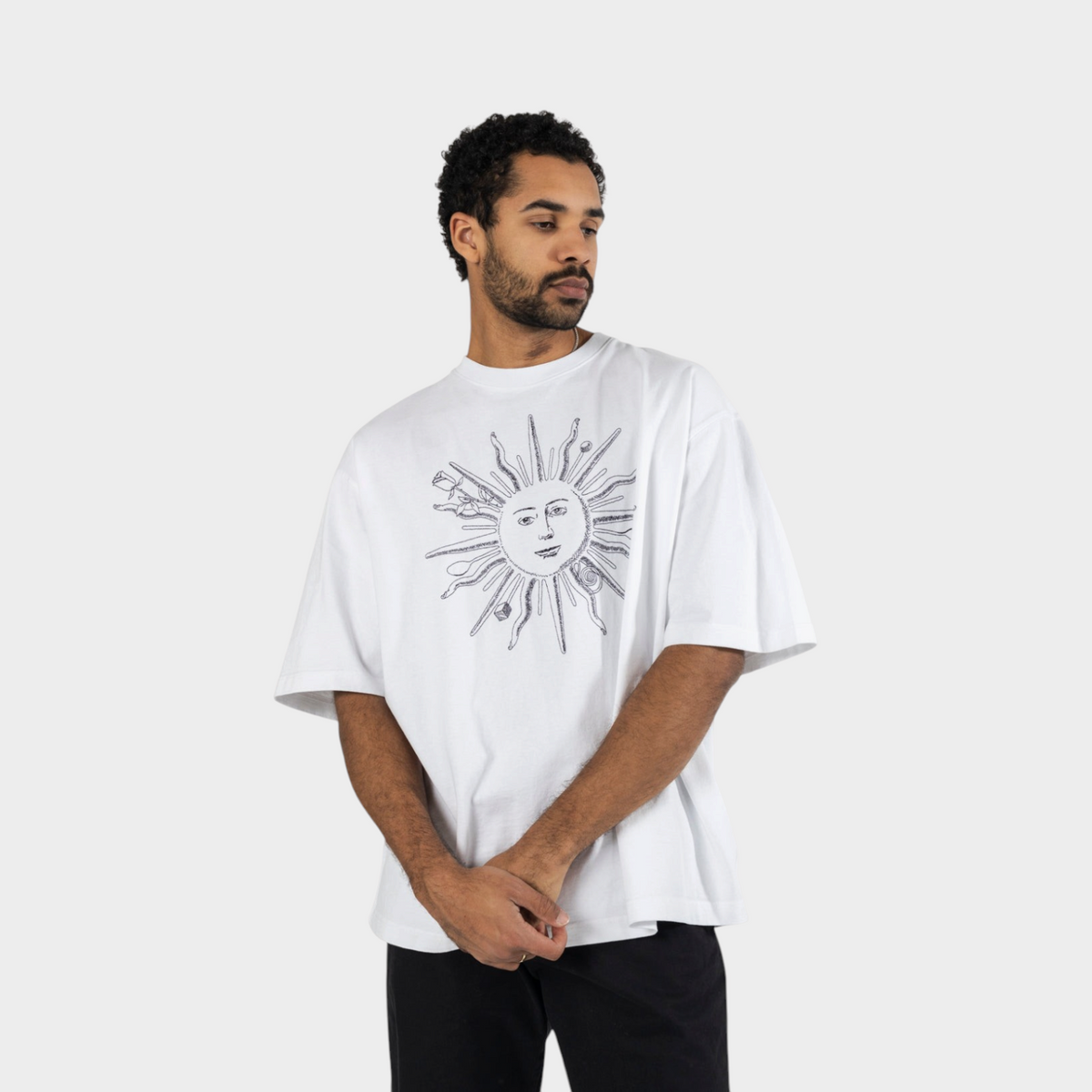 Supplied Fashion white cotton t-shirt with a black sun graphic print worn by a man looking to the side