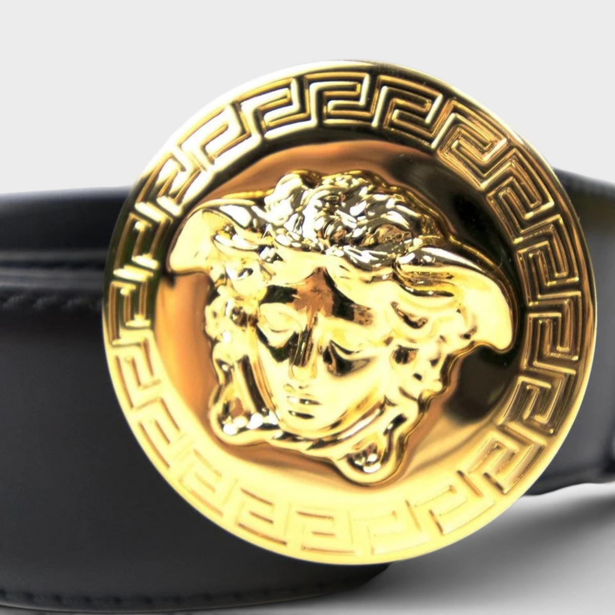 Supplied Fashion black leather belt featuring a round gold Medusa head medallion buckle with Greek key border