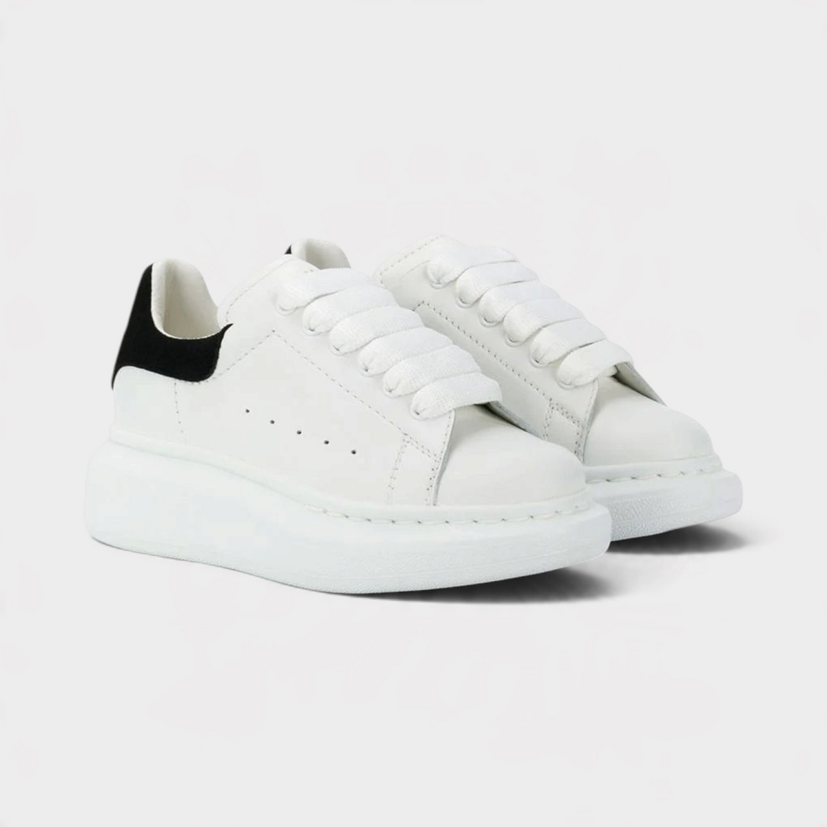 Supplied Fashion kids' white and black sneakers with chunky oversized soles and wide laces for a streetwear look.