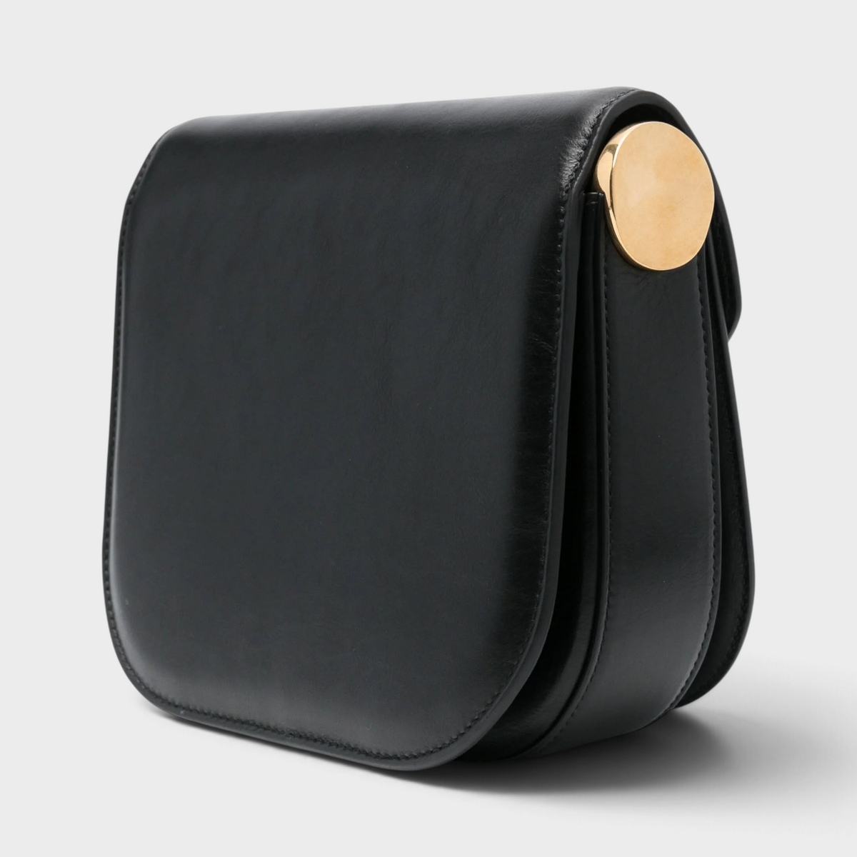 Supplied Fashion Medium Coin black leather crossbody bag with a minimalist structured silhouette and gold coin detail.