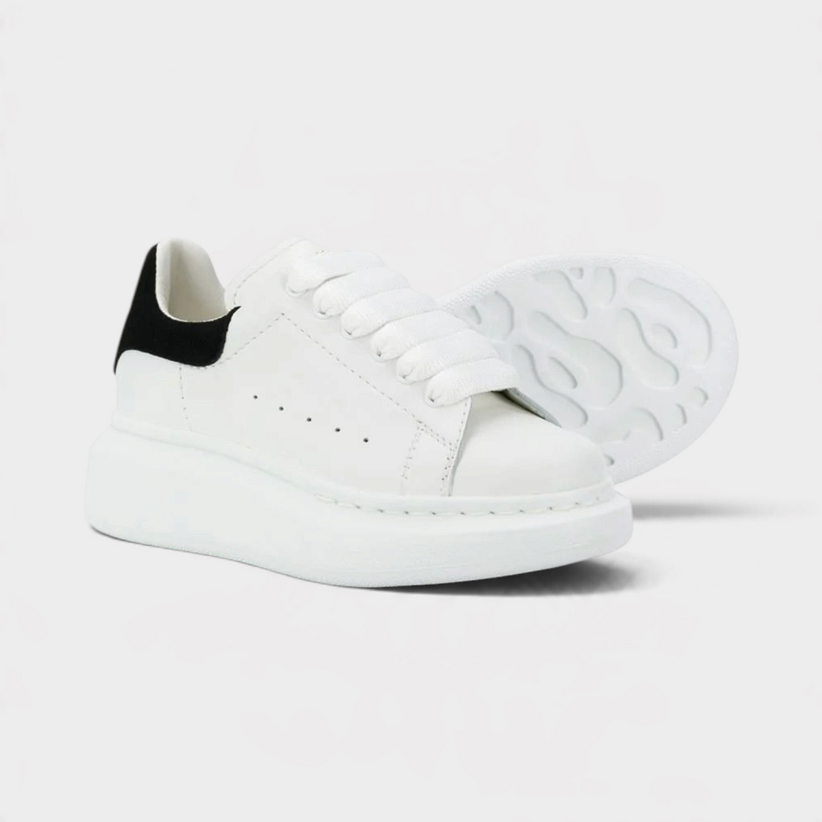 Supplied Fashion kids' white and black sneakers with a chunky oversized sole and wide laces for a streetwear look.