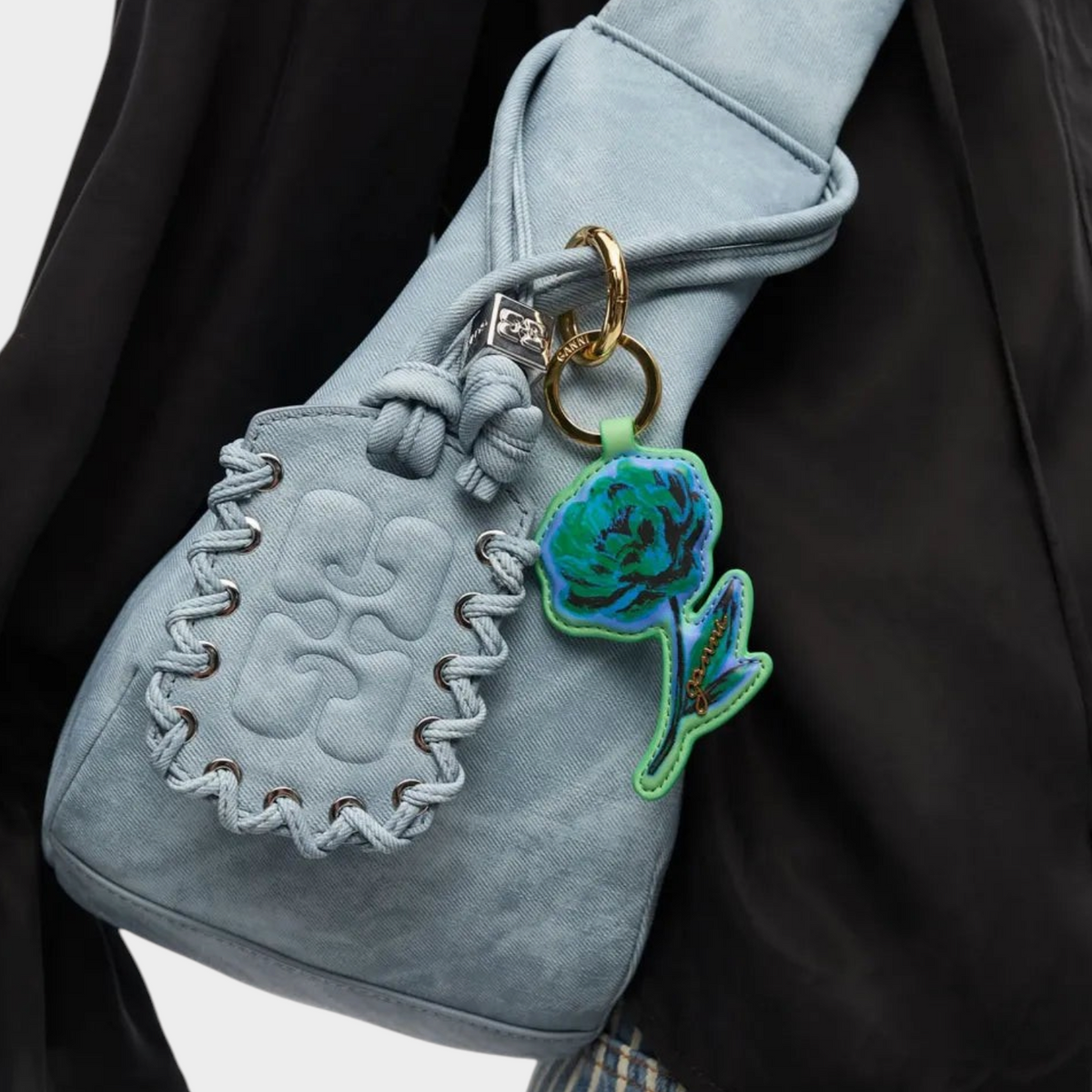 Supplied Fashion stone green flower keyring attached to a blue suede shoulder bag with braided detailing