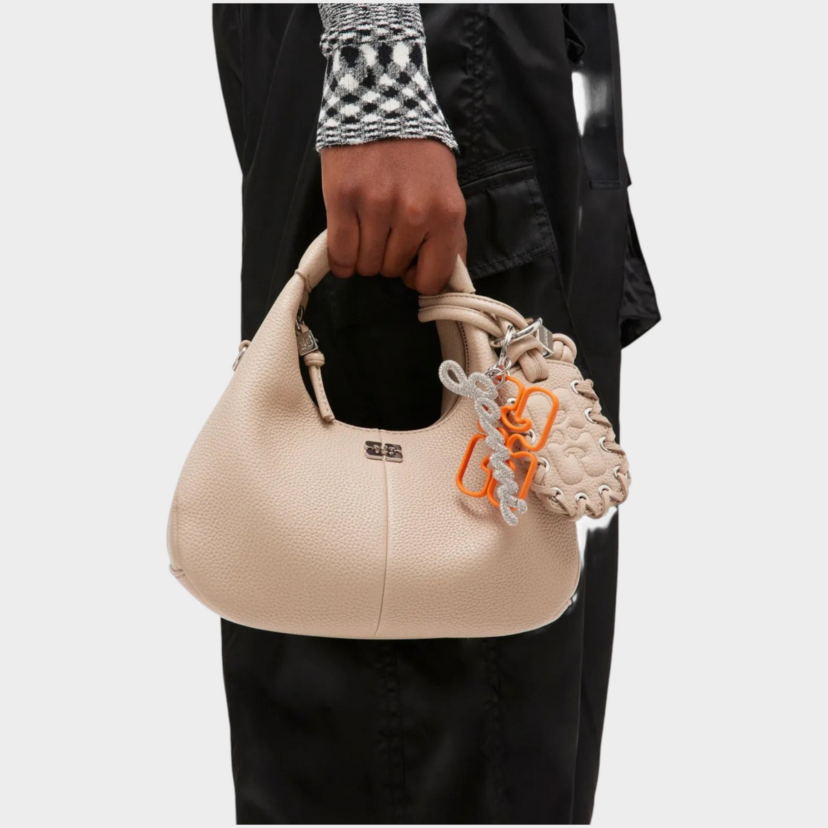 Supplied Fashion GANNI russet orange chain embellished keyring attached to a beige leather handbag