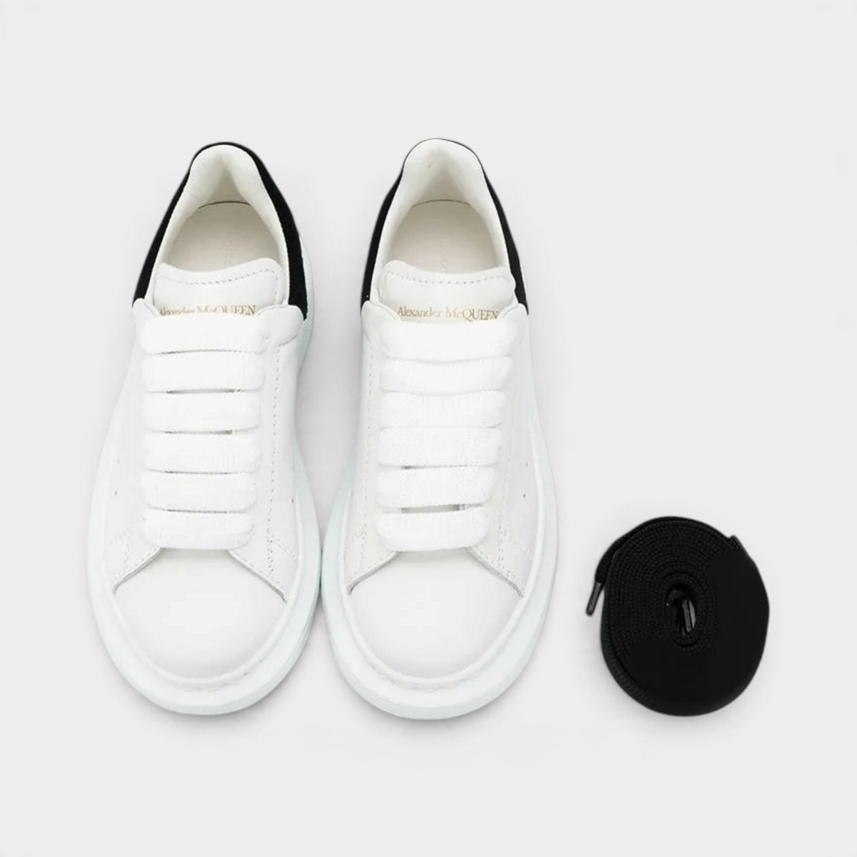 Supplied Fashion kids' white and black leather sneakers with chunky oversized soles and extra black laces.