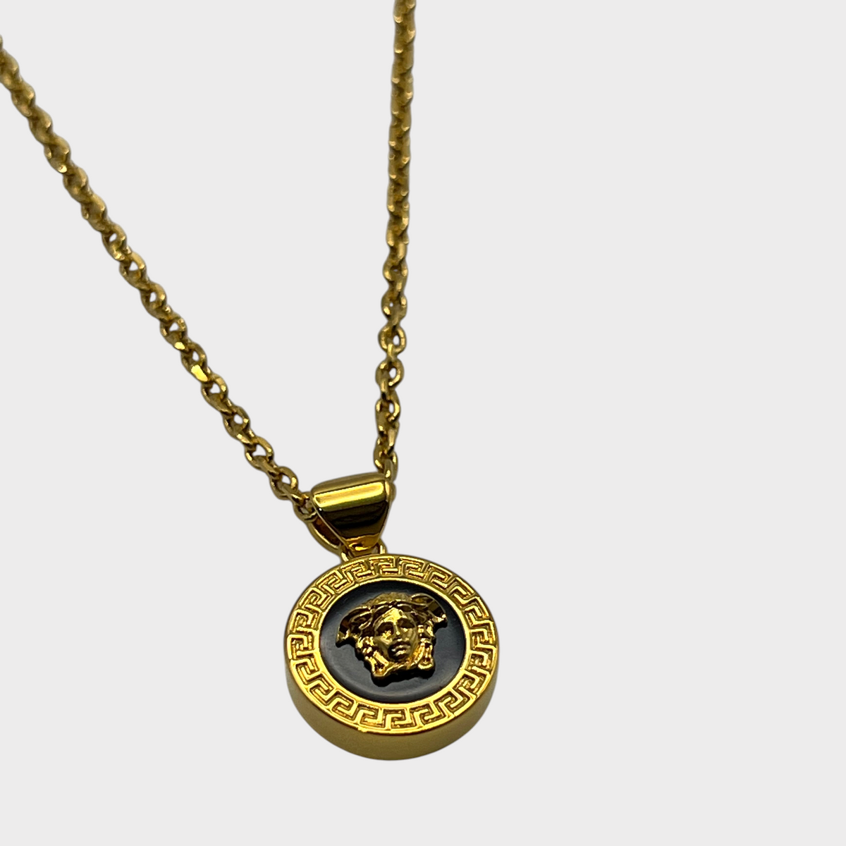 Supplied Fashion Medusa head pendant necklace featuring a black and gold circular design with a Greek key border.