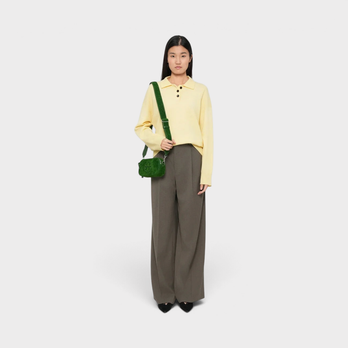 Model wearing a Supplied Fashion emerald green flocked leather Miller mini crossbody bag with gold-tone logo hardware