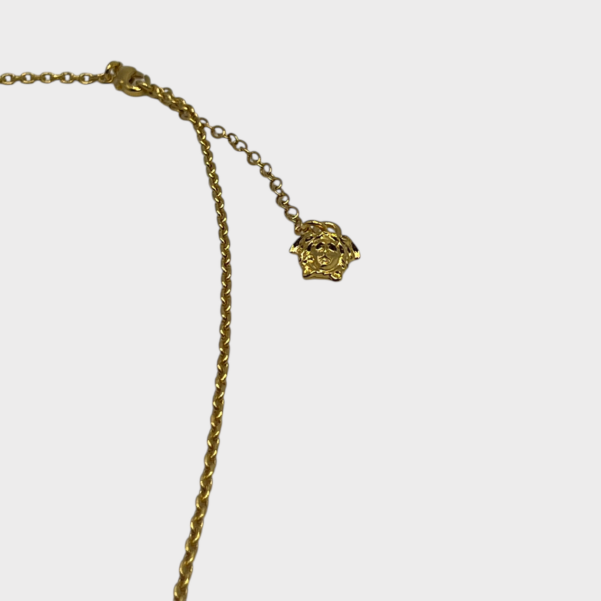 Supplied Fashion gold chain necklace featuring a small Medusa head pendant charm on a delicate link chain