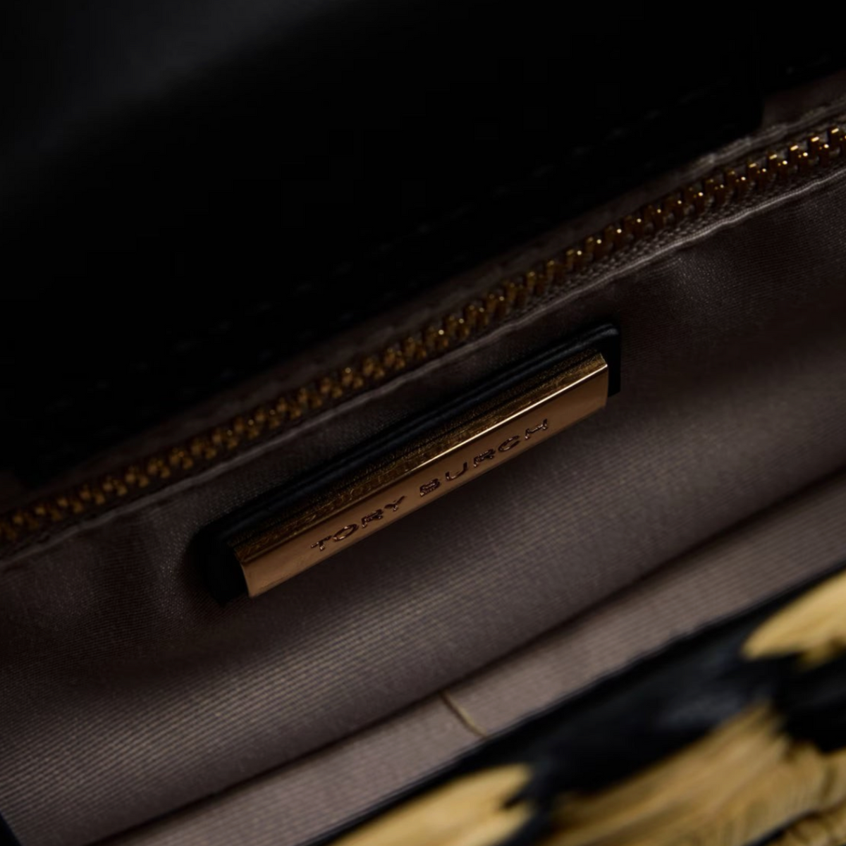 Supplied Fashion Ella hand-crocheted bag interior featuring a gold Tory Burch logo plaque and fabric lining.