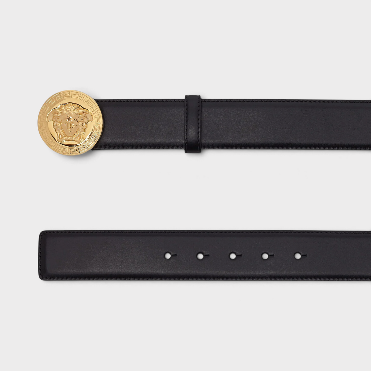 Supplied Fashion black leather belt featuring a round gold Medusa head buckle with intricate Greek key detailing.