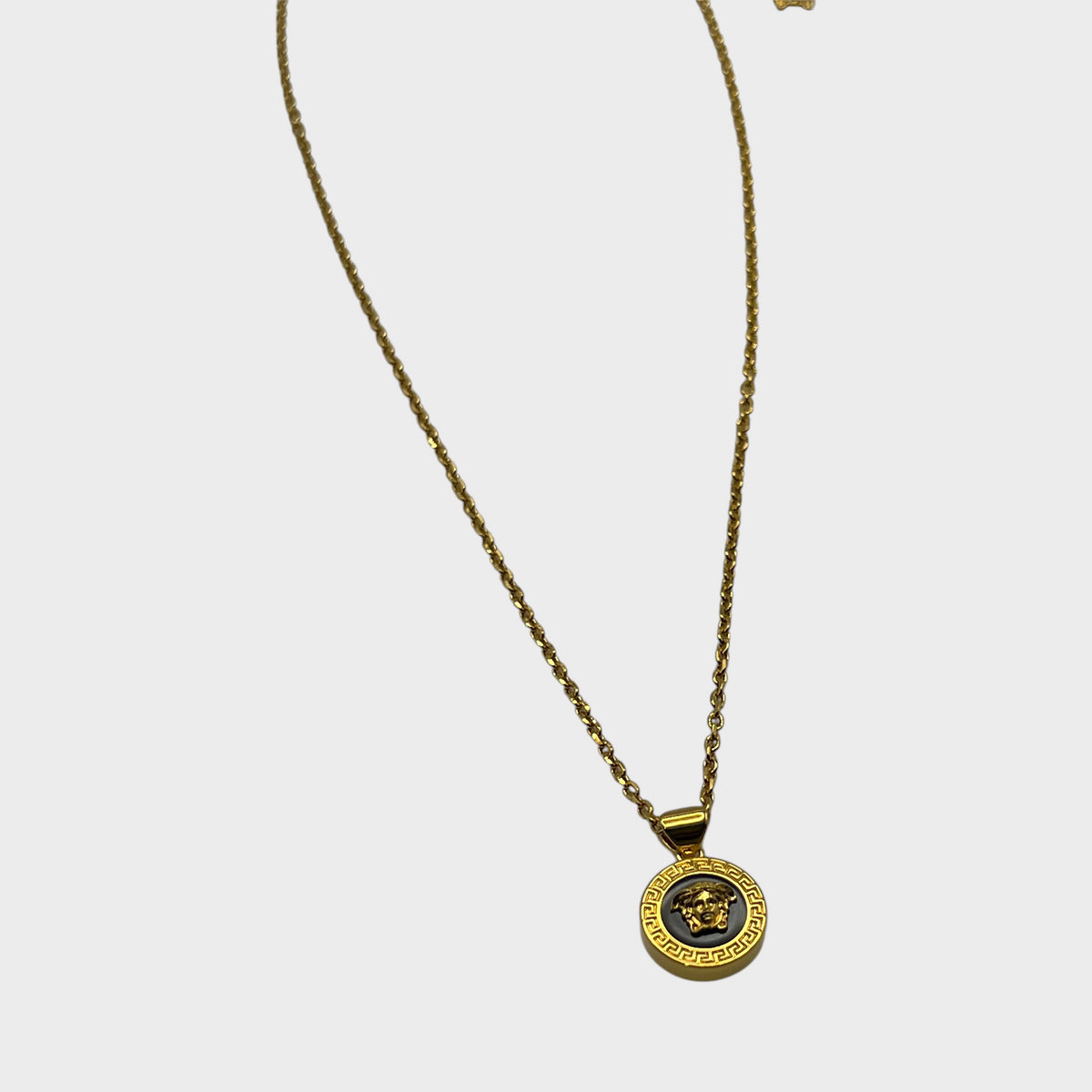 Supplied Fashion black and gold Medusa head pendant necklace with a textured gold chain for a luxury streetwear look.