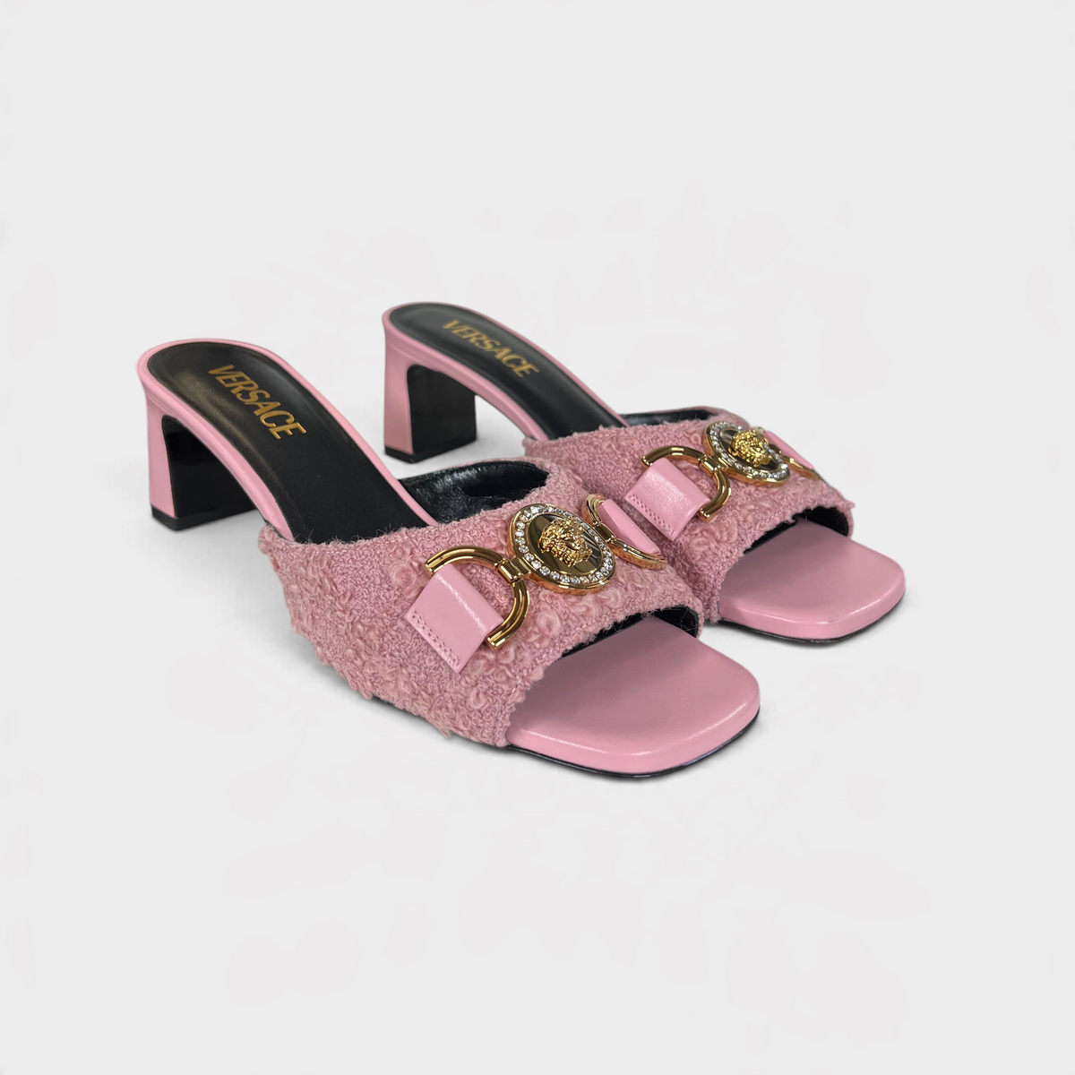 Supplied Fashion pink tweed mules with gold Medusa head hardware and block heels on a white Versace branded box.