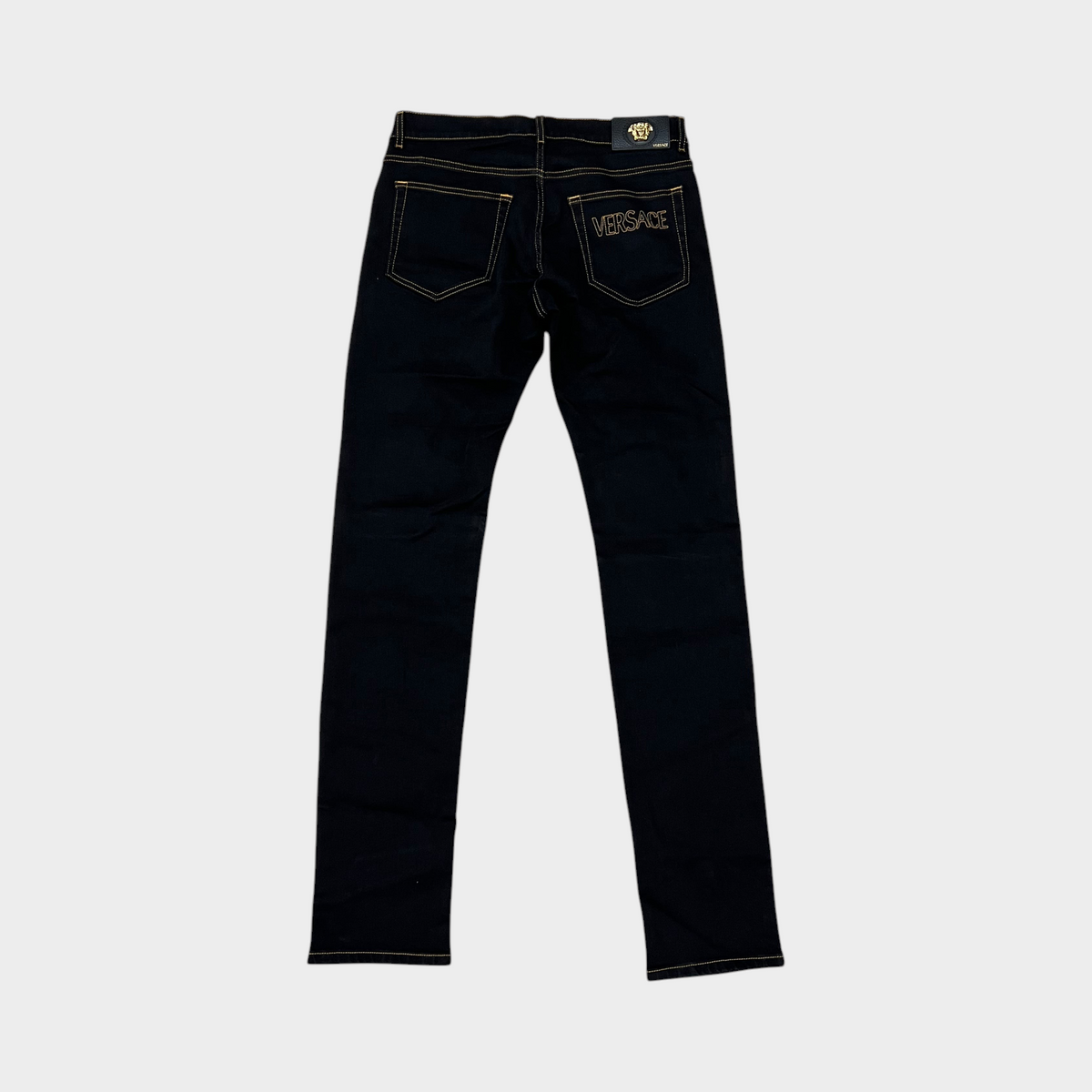 Supplied Fashion black stretch denim jeans with gold Medusa head motif and Versace back pocket embroidery