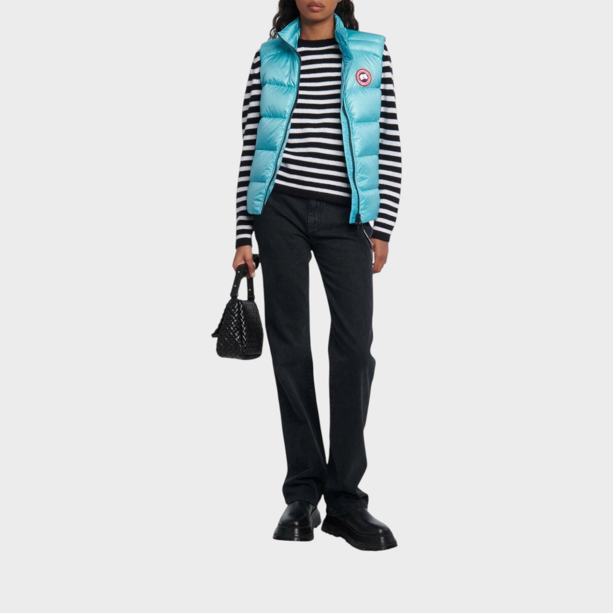 Supplied Fashion Canada Goose Cypress down vest in boulevard blue worn over a striped sweater and black jeans.
