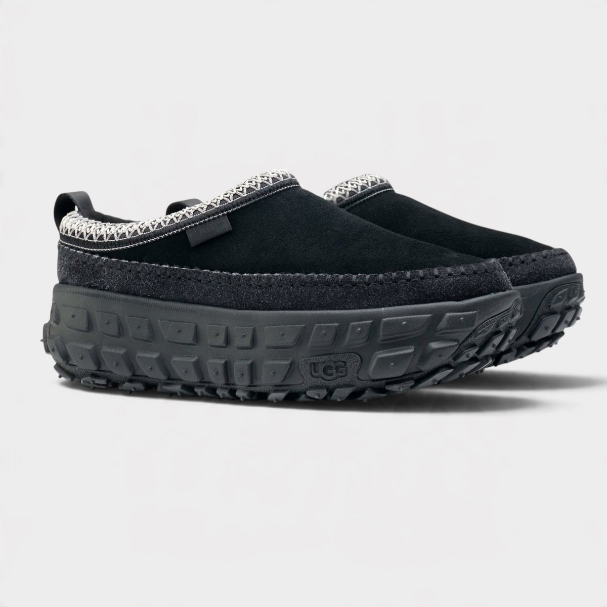 Supplied Fashion Venture Daze black slip-on shoes with suede upper, thick textured rubber sole, and patterned trim.