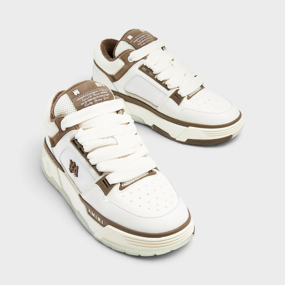 Supplied Fashion AMIRI MA-1 low-top sneakers in white and brown leather with thick laces and signature branding.