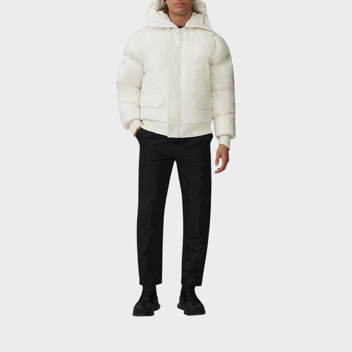 Supplied Fashion Paradigm Chilliwack white down bomber jacket with a hood, worn by a model with black trousers.