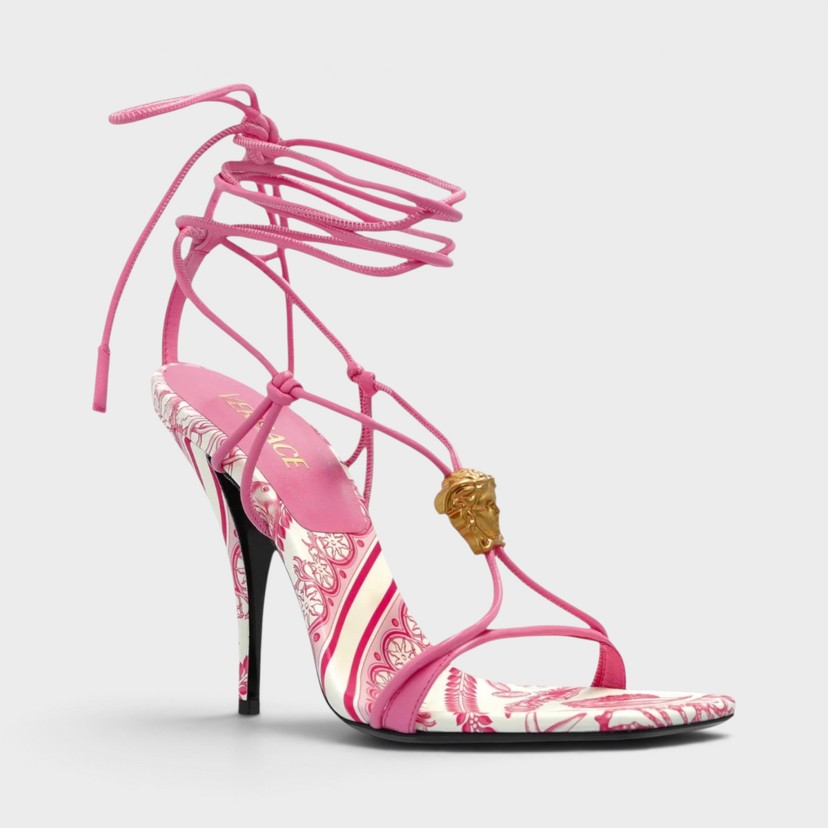 Supplied Fashion pink and white Medusa Barocco square-toe heeled sandals with gold hardware and lace-up ankle straps.