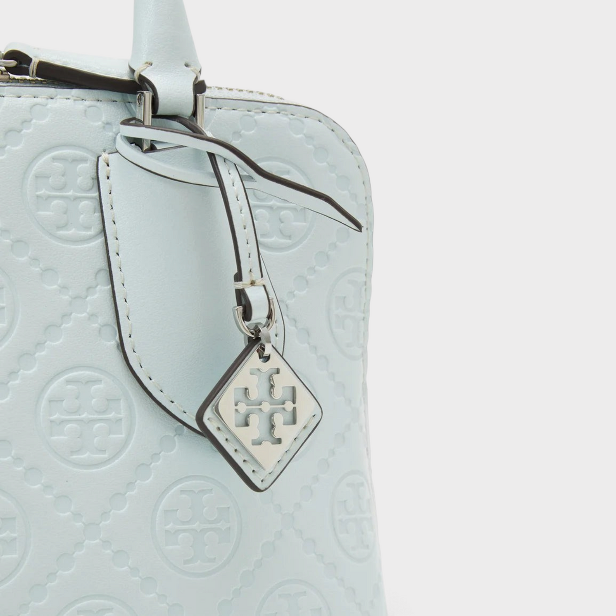 Supplied Fashion ice blue leather mini swing bag with embossed monogram T logo and silver charm detail