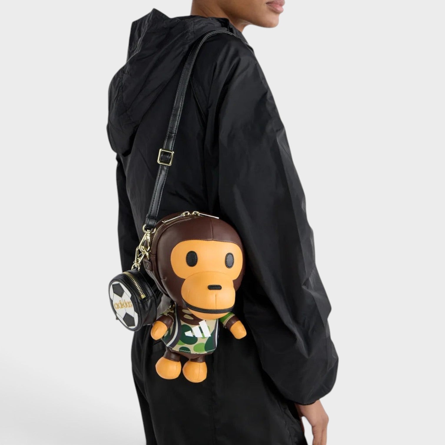 Supplied Fashion adidas x BAPE Baby Milo bag in auburn featuring a character design with a camo shirt and soccer charm