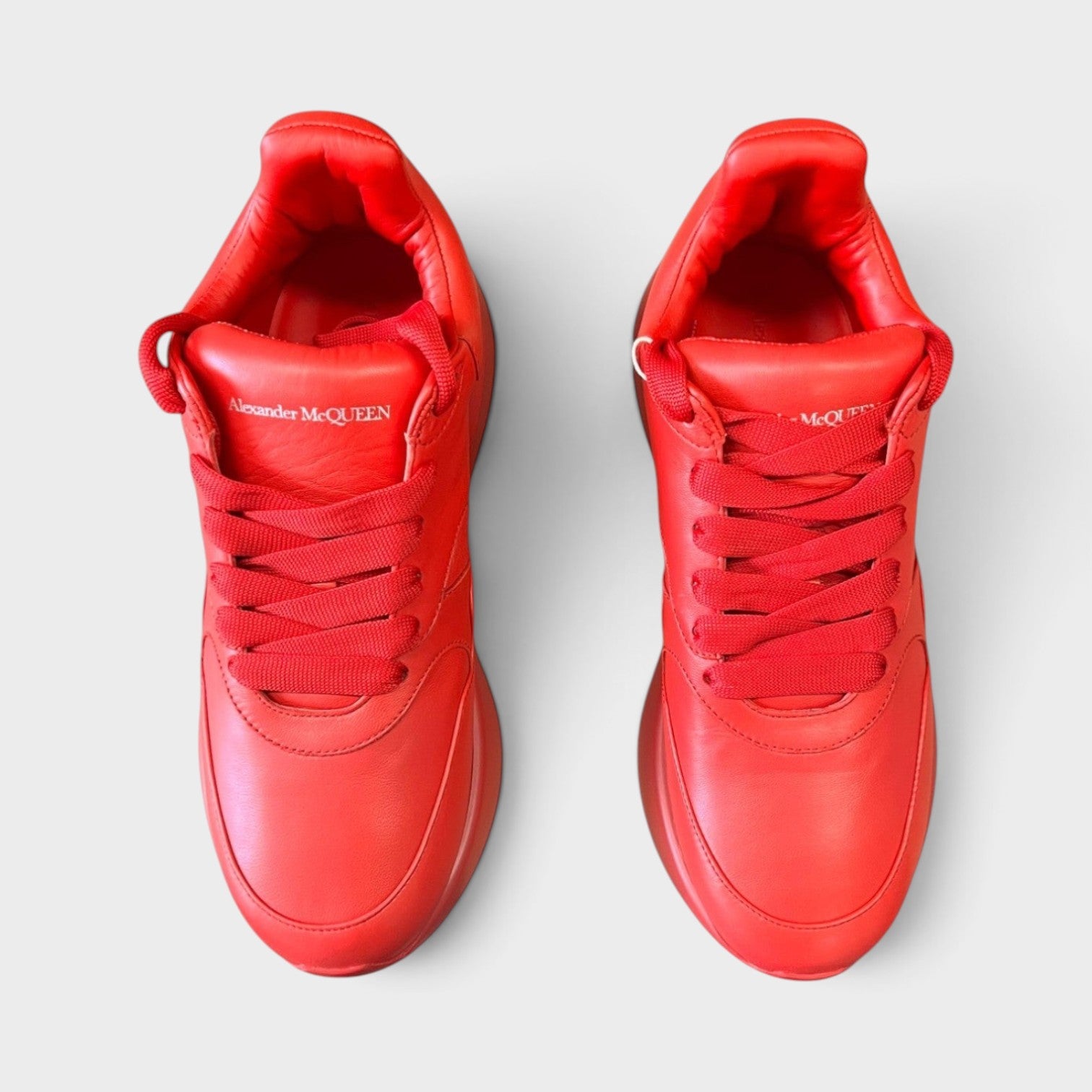 Supplied Fashion Alexander McQueen red leather oversized runner sneakers with signature thick soles, top view.