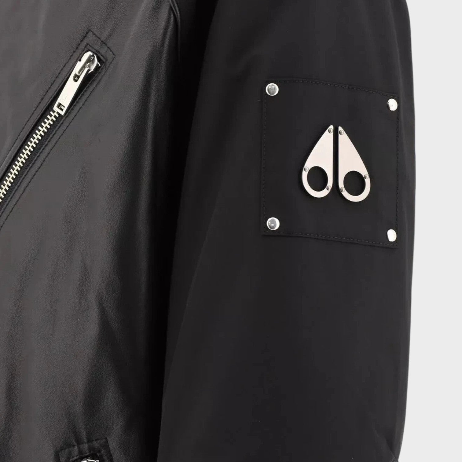 Supplied Fashion Anica black leather bomber jacket featuring a metal logo patch on the sleeve and silver zipper detail.
