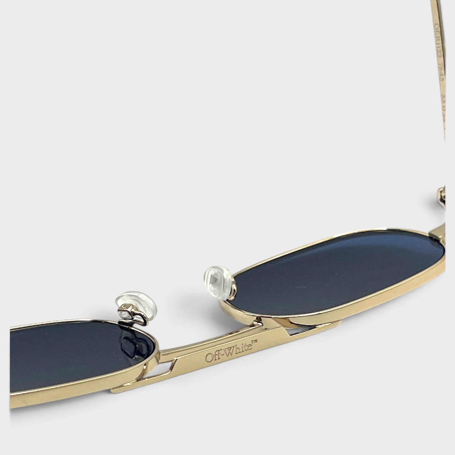 Supplied Fashion Baltimore Arrow sunglasses featuring a silver frame, dark lenses, and Off-White branding detail.
