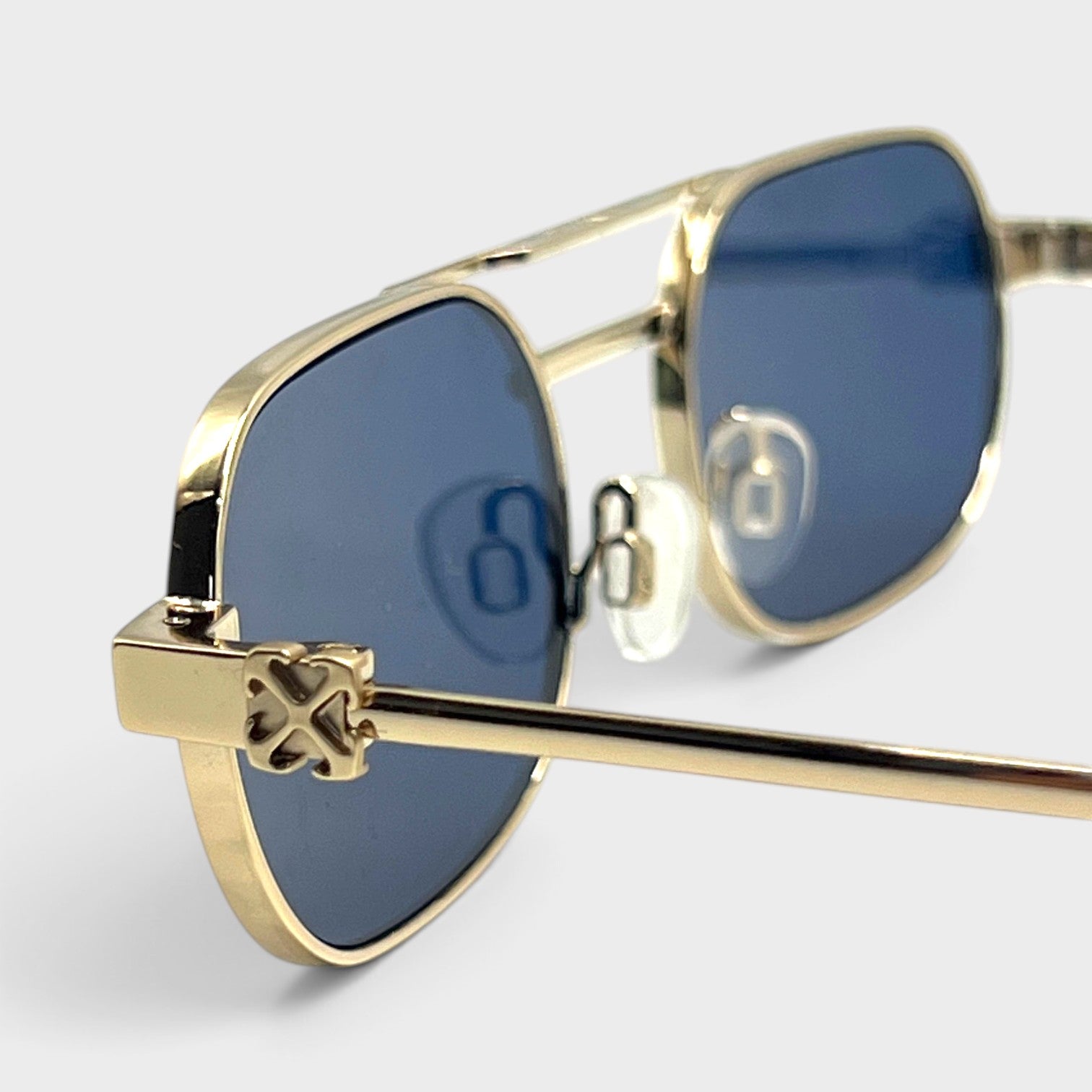 Supplied Fashion Baltimore Arrow sunglasses featuring a silver frame, blue tinted lenses, and signature arrow detail.