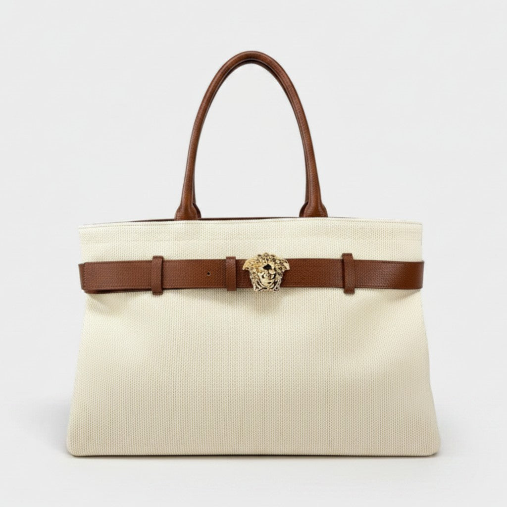 Supplied Fashion beige canvas tote bag with brown leather handles, belt detail, and gold Medusa head emblem.