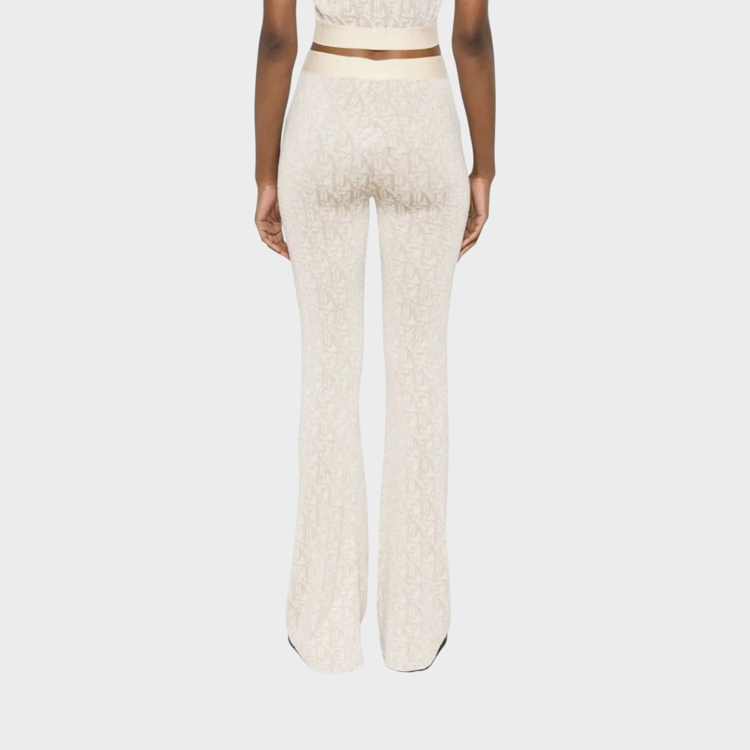 Supplied Fashion beige monogram jacquard knitted flared trousers with a metallic logo waistband, back view.