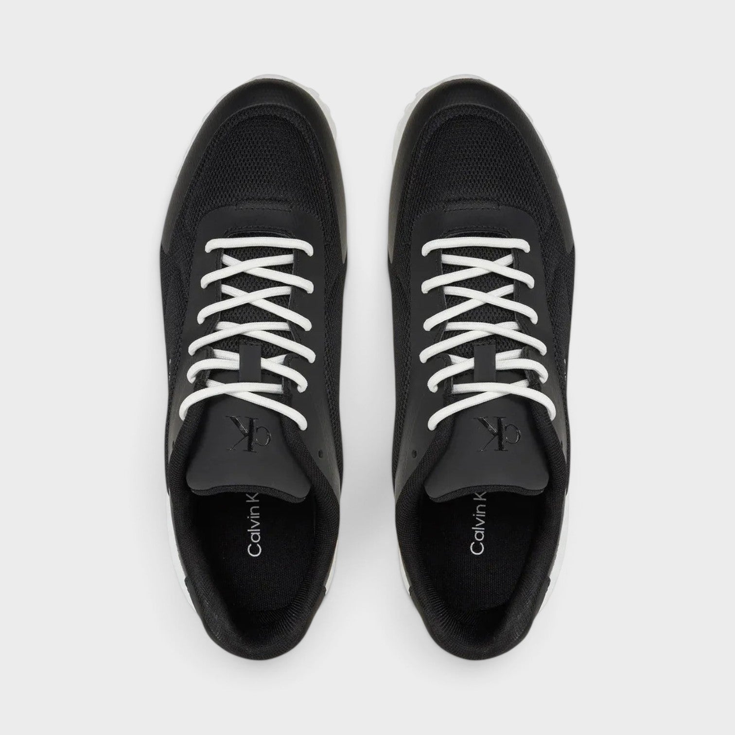 Supplied Fashion Calvin Klein Eva Runner low-top sneakers in black mesh and leather with white laces, top-down view.