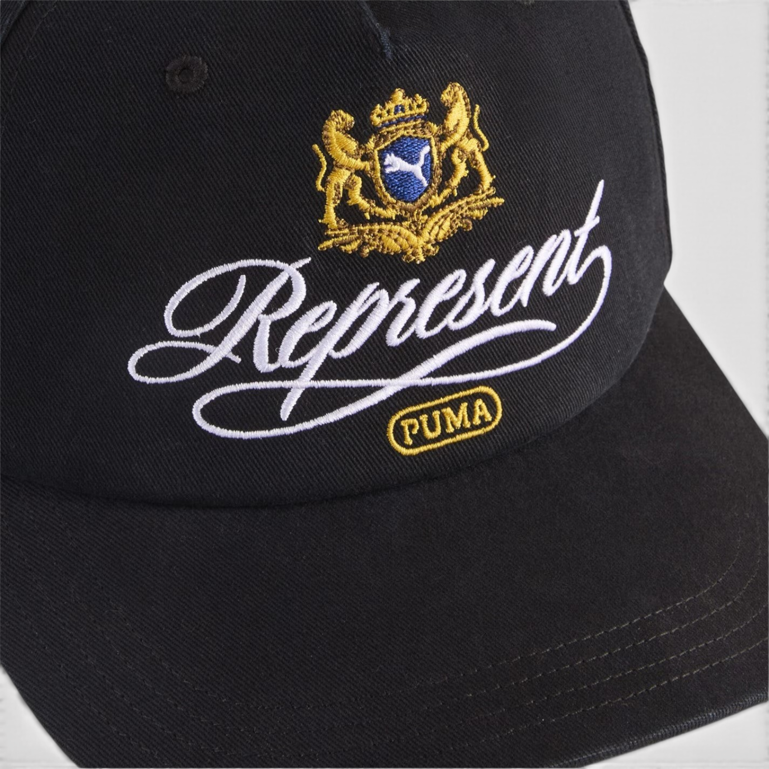 Supplied Fashion black baseball cap with detailed gold and white embroidered Puma logo crest and script text