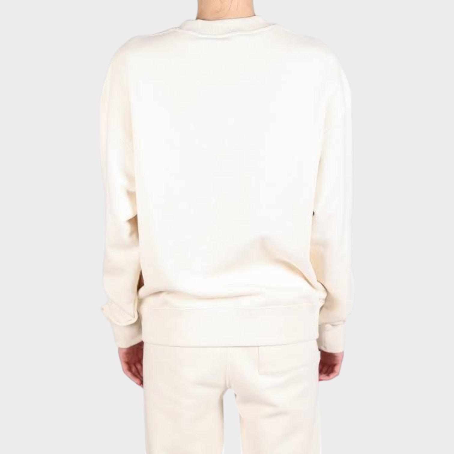 Back view of a cream Jil Sander terry logo sweatshirt worn by a model, showcasing a relaxed fit and minimalist style.