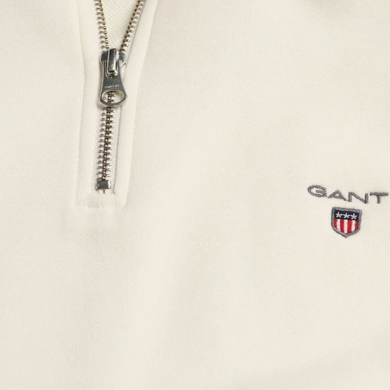 Supplied Fashion GANT cream half-zip sweater featuring a silver metal zipper and embroidered shield logo on the chest.
