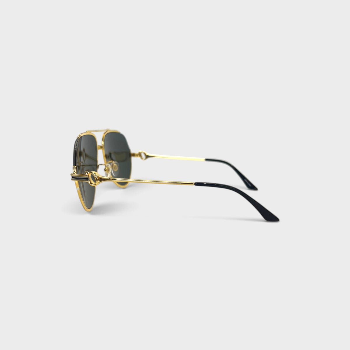 Supplied Fashion rounded sunglasses with gold metal frames and black temple tips, side view on a light background.