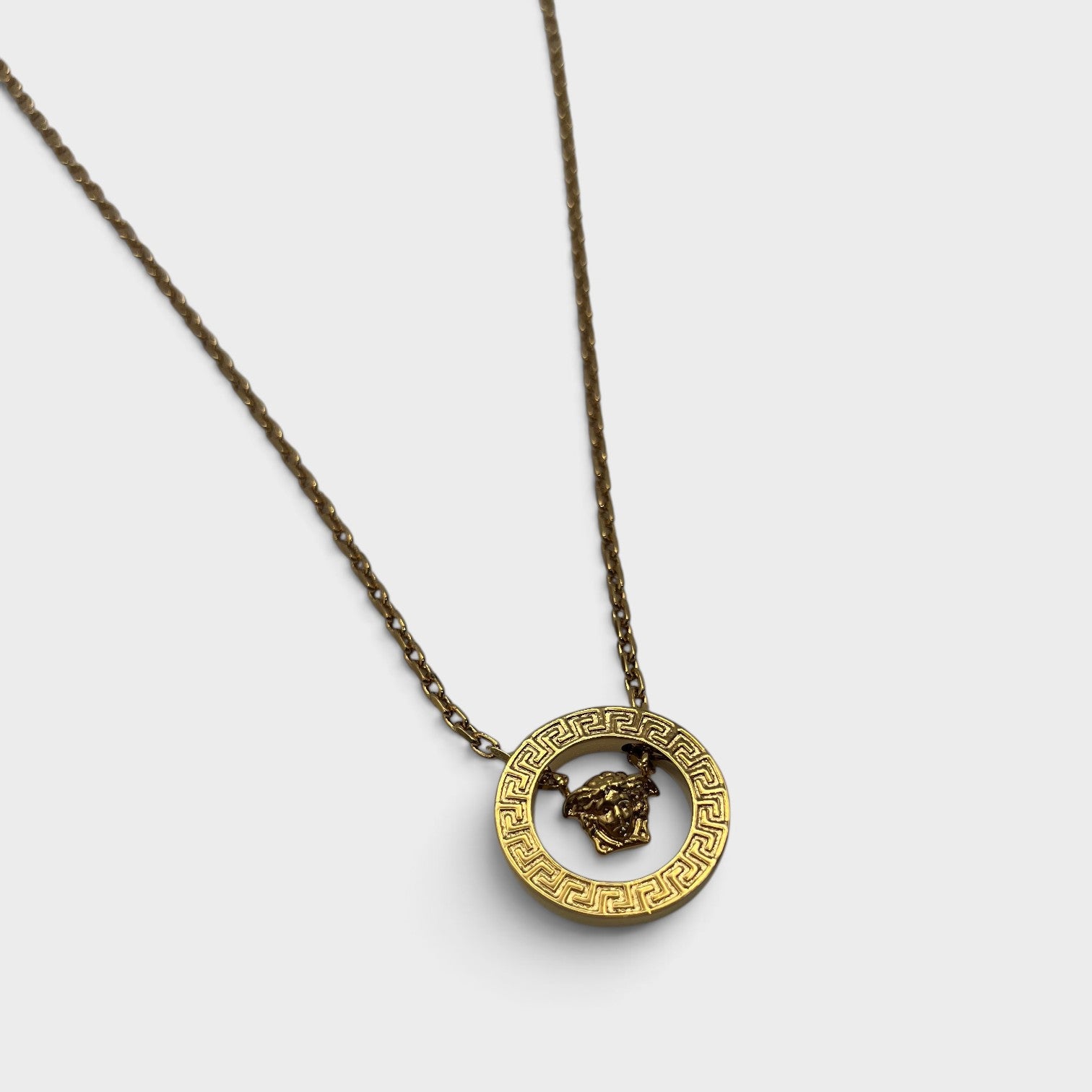 Supplied Fashion gold Medusa Greca necklace featuring a circular pendant with iconic Greek key motif and Medusa head.