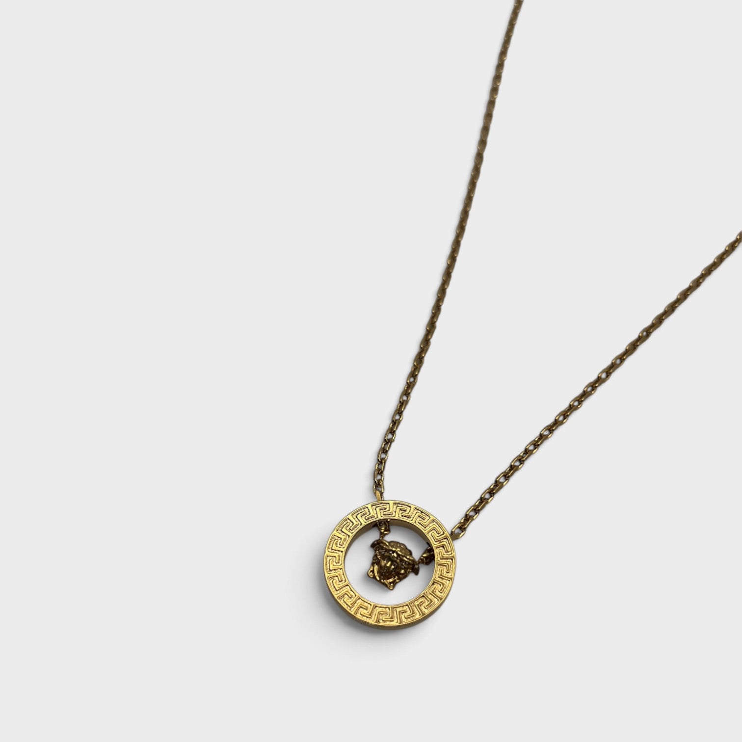Supplied Fashion gold Medusa Greca necklace featuring a circular pendant with iconic Greek key pattern and Medusa head