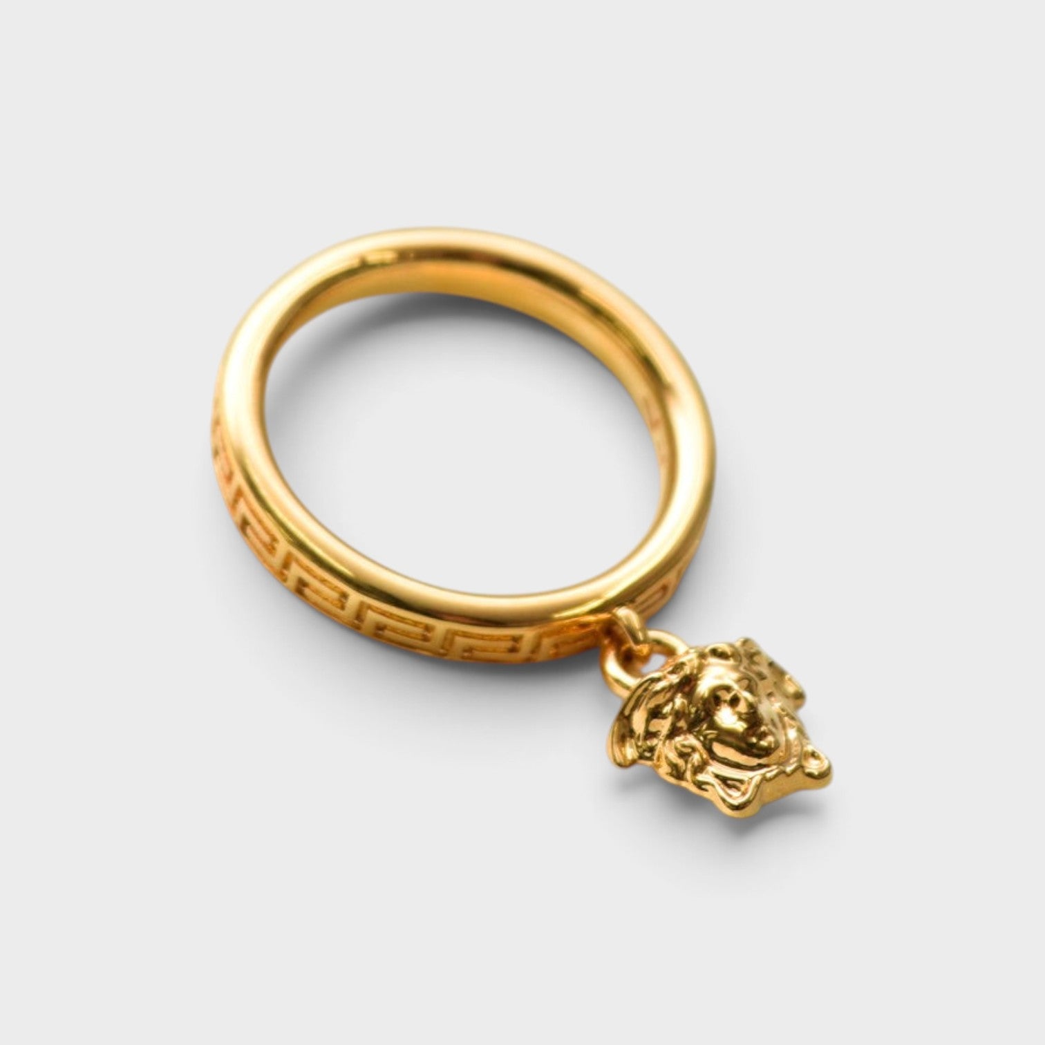 Supplied Fashion gold ring featuring a Medusa head charm and engraved Greca pattern band