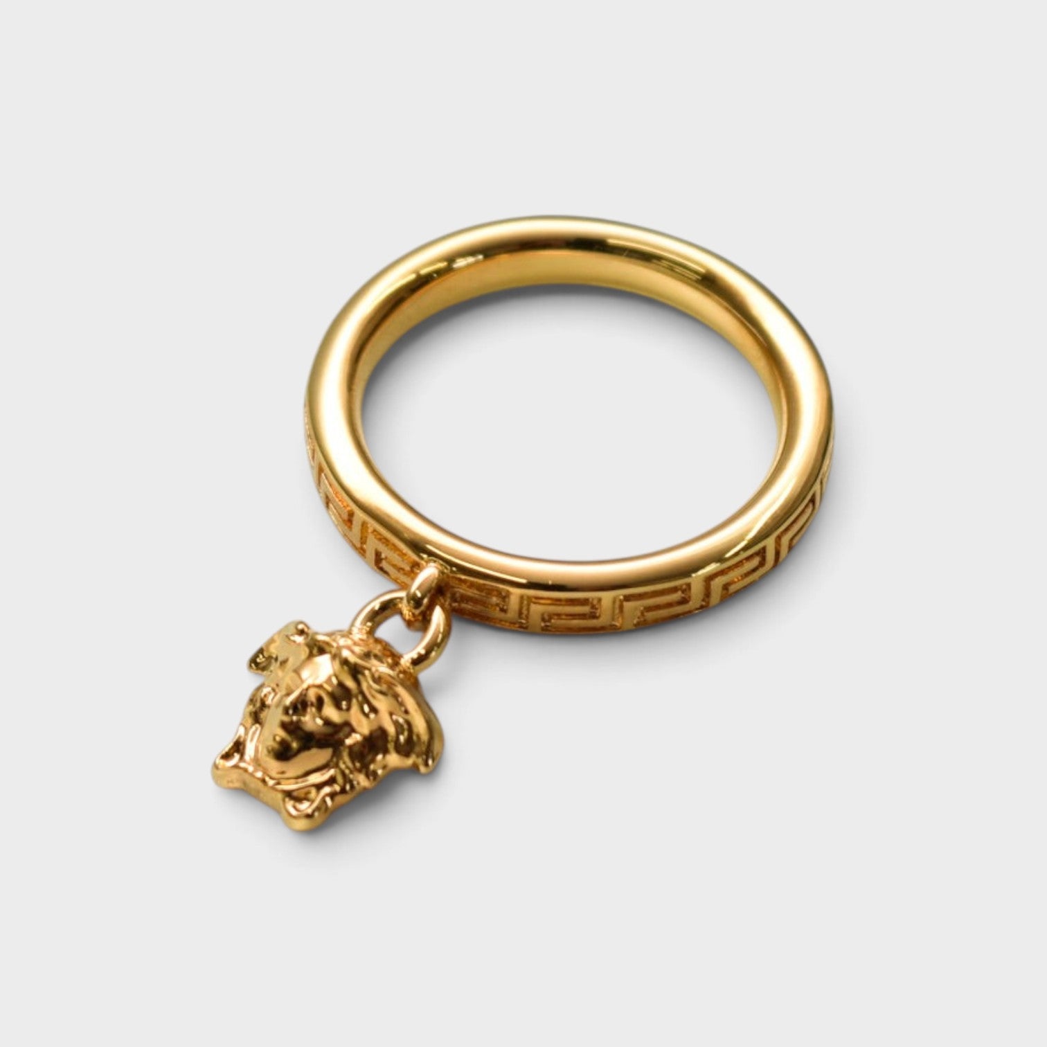 Supplied Fashion gold ring featuring a Medusa head charm and intricate Greca pattern engraving on the band.