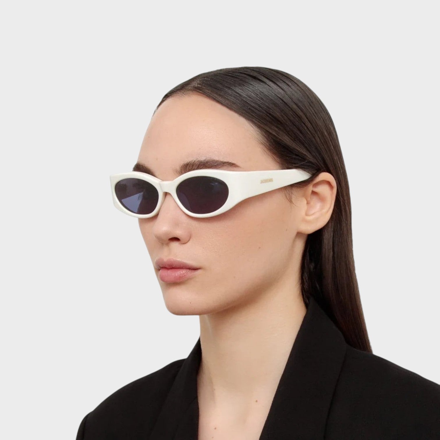 Supplied Fashion Jacquemus x Linda Farrow Ovalo oval sunglasses in white worn by a model in a black blazer