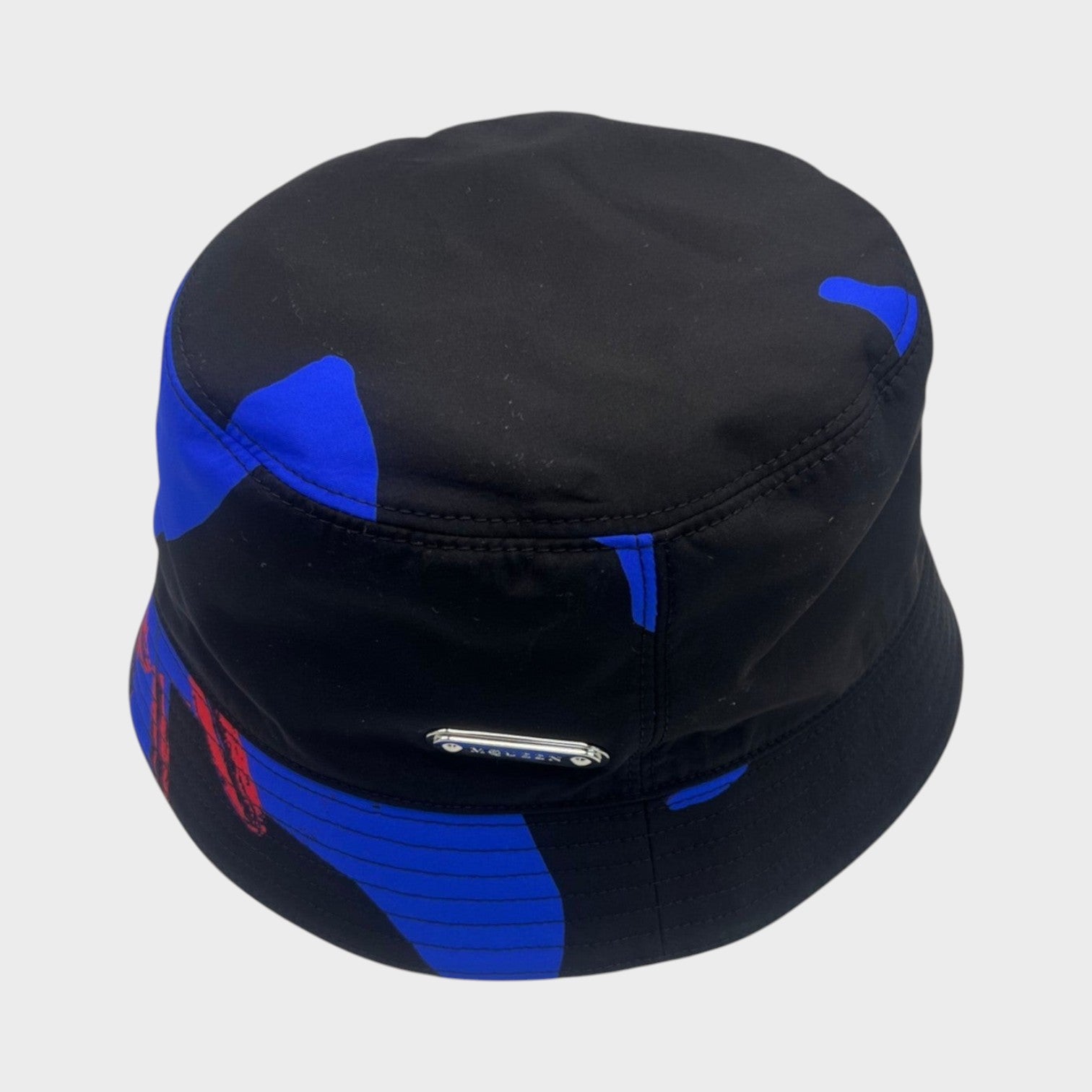 Supplied Fashion Lily bucket hat in black with blue and red abstract print and a silver metal logo plaque