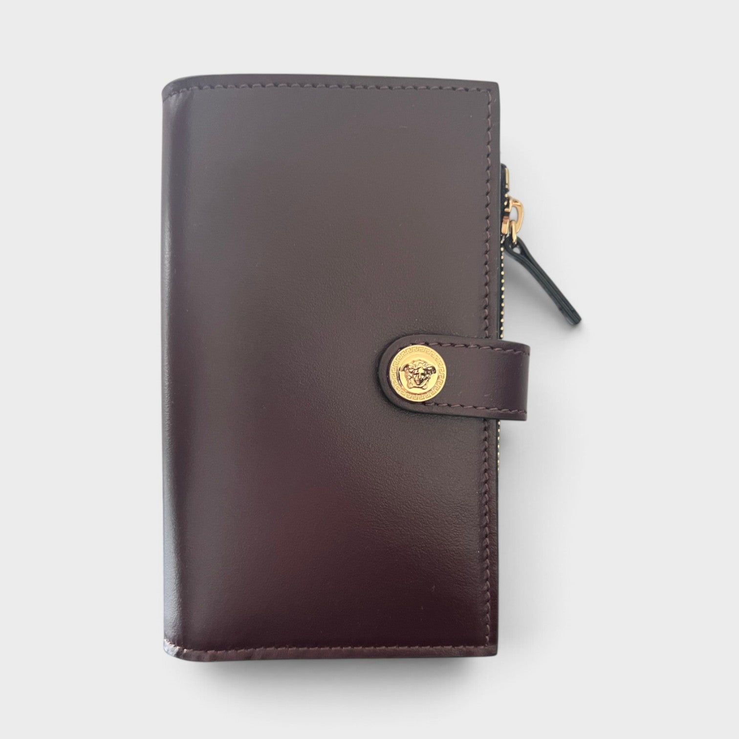 Supplied Fashion maroon brown calf leather compact wallet featuring a gold Medusa head snap button closure