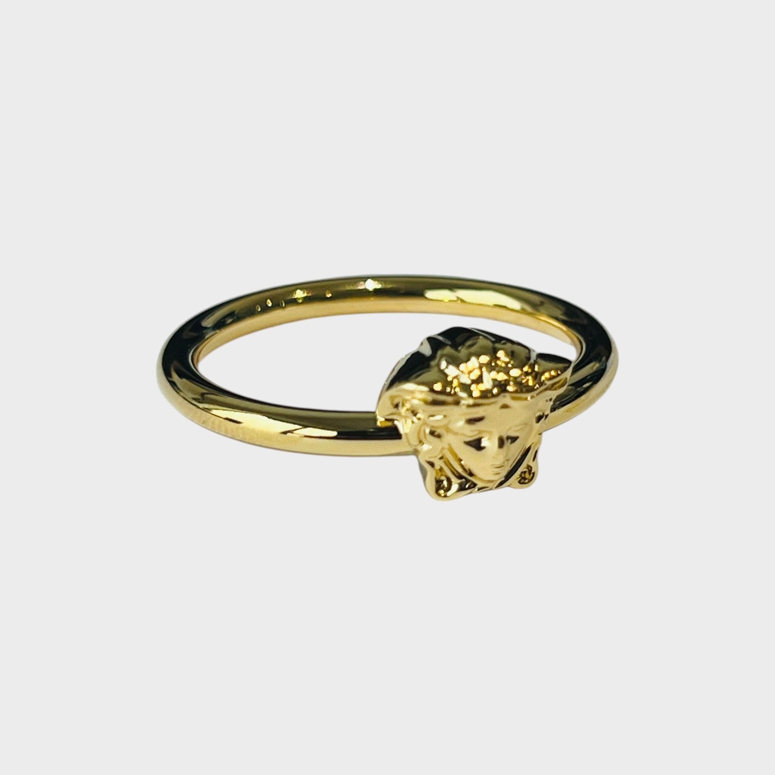 Supplied Fashion gold tone metal ring featuring a detailed Medusa head design. Edgy, artistic jewellery with historical flair.