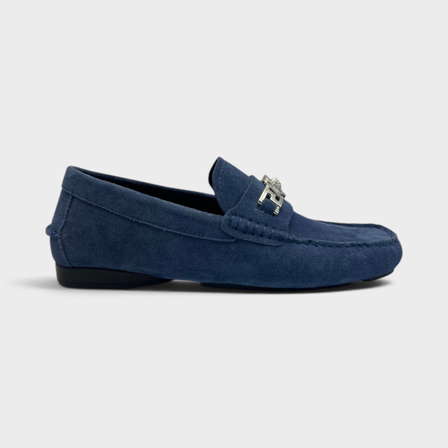 Supplied Fashion navy suede Medusa Greca driver loafer with silver metal hardware detail on a neutral background.