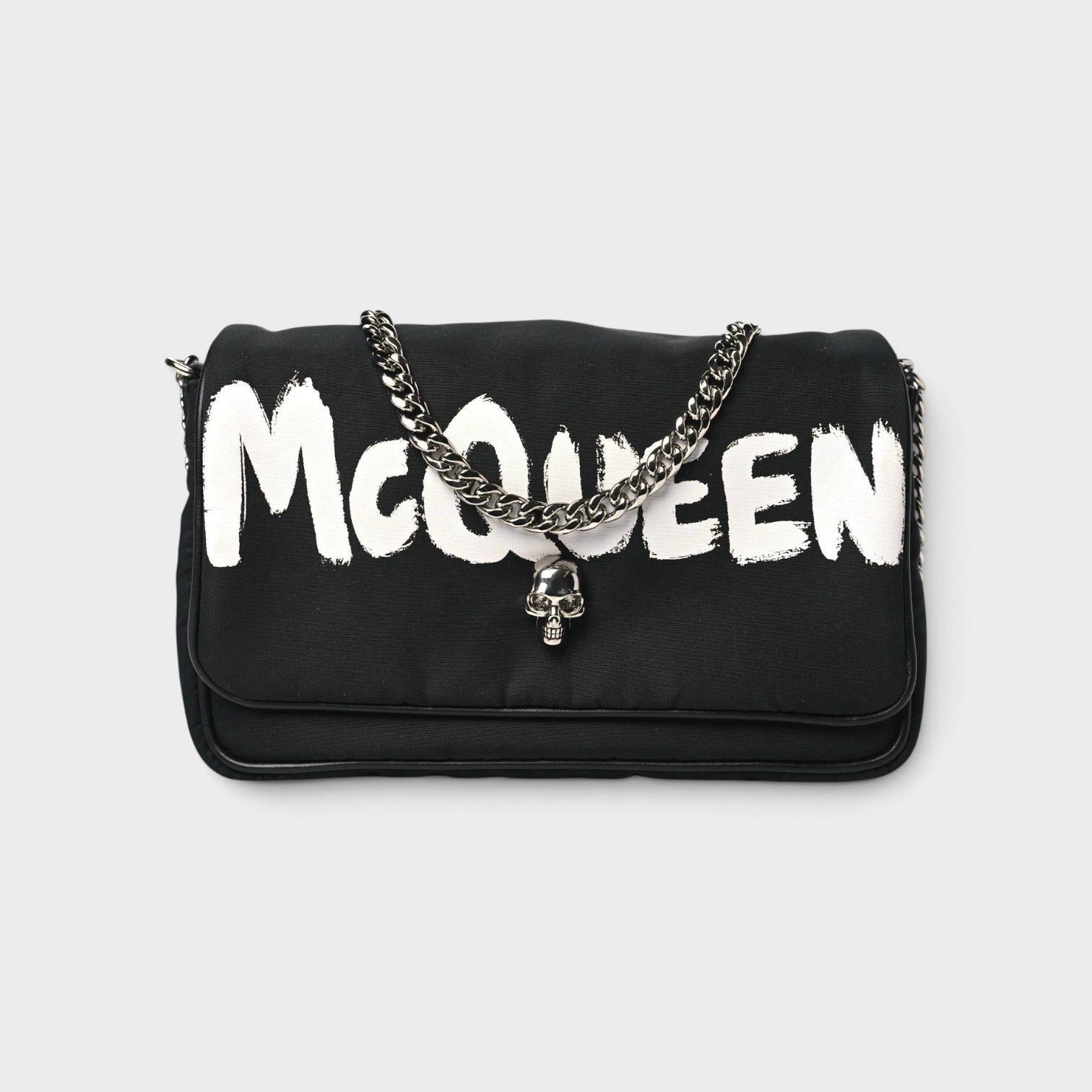 Supplied Fashion black nylon crossbody bag with white graffiti logo and silver skull charm on a chain strap