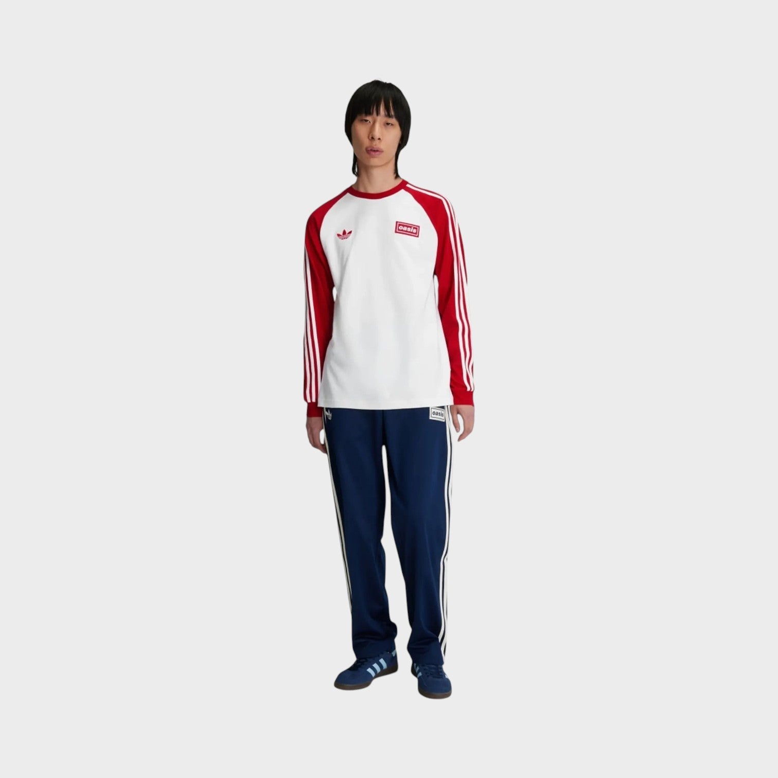Supplied Fashion Oasis Tour long-sleeve tee in white with red sleeves and 3-Stripes worn by a model in blue track pants