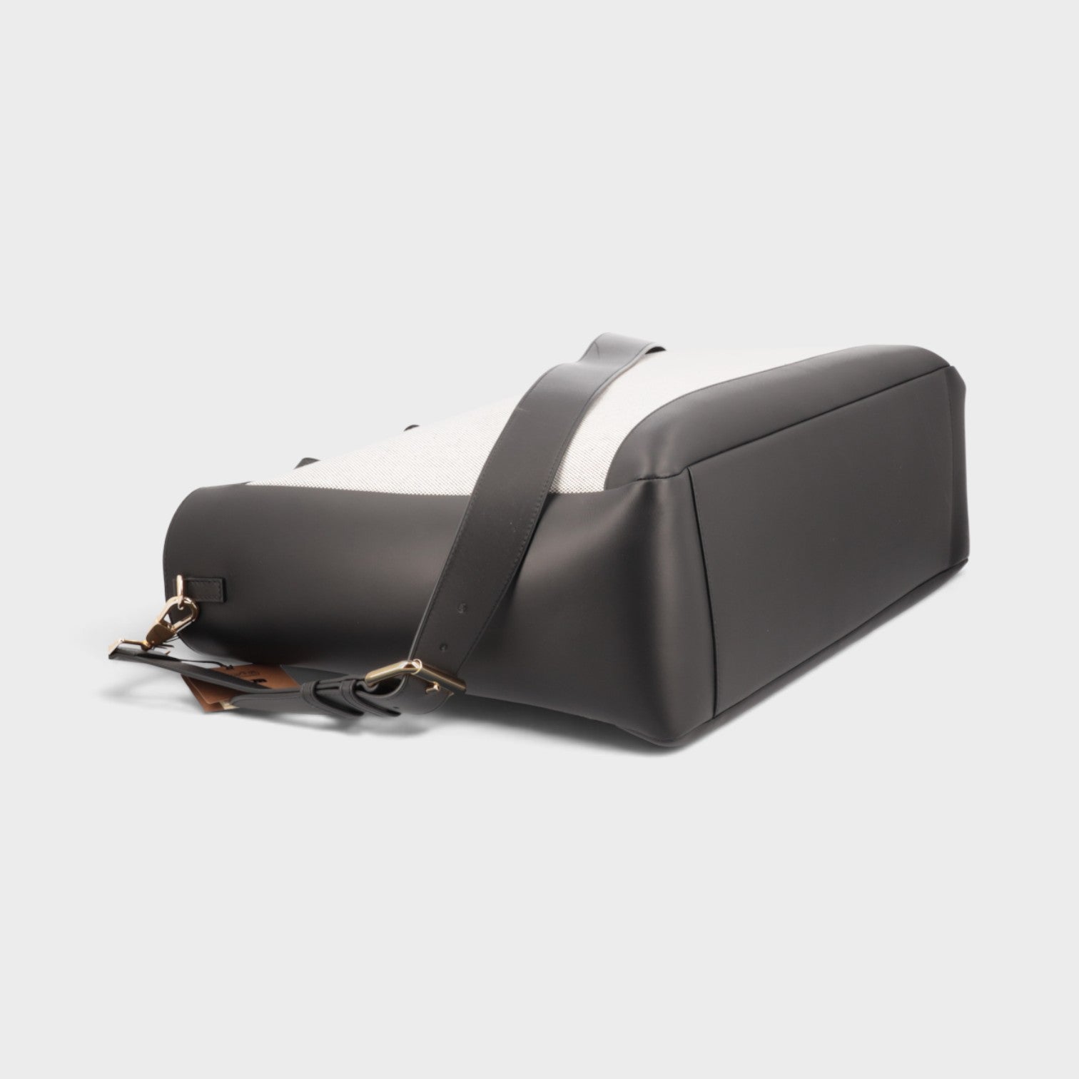 Supplied Fashion Burberry Ormond two-way tote bag in beige canvas and black leather, shown from a side angle.