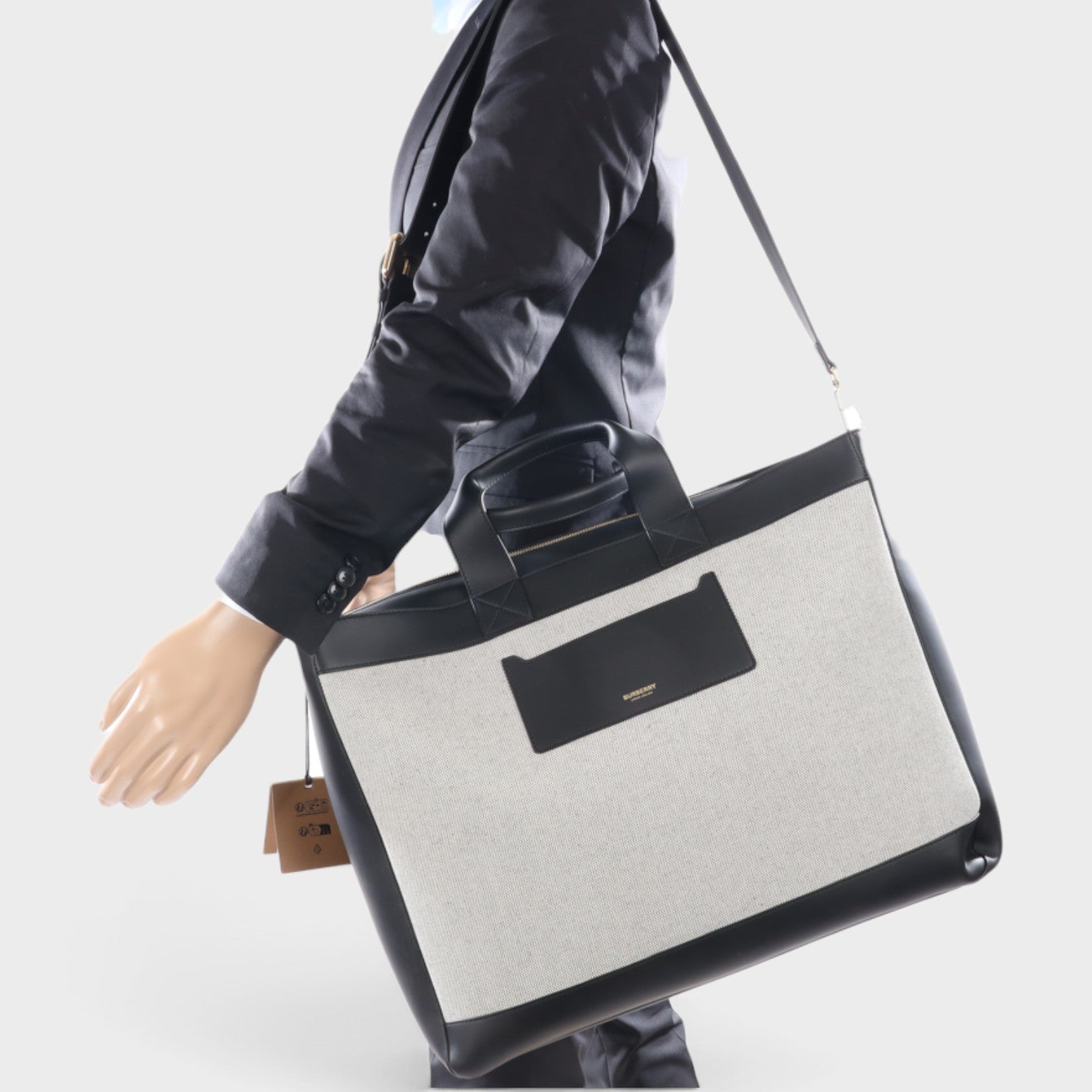 Supplied Fashion Burberry Ormond beige and black canvas leather tote bag worn on shoulder by mannequin