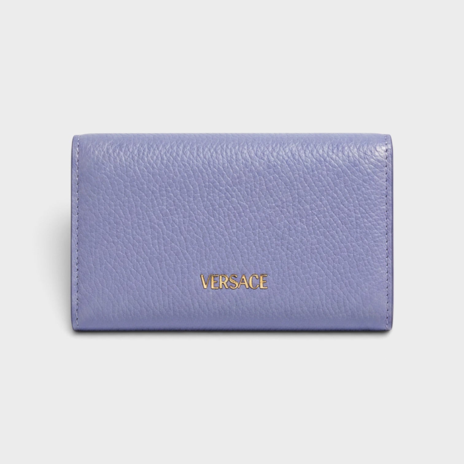 Supplied Fashion purple leather business card holder with gold Versace logo lettering on a clean background.