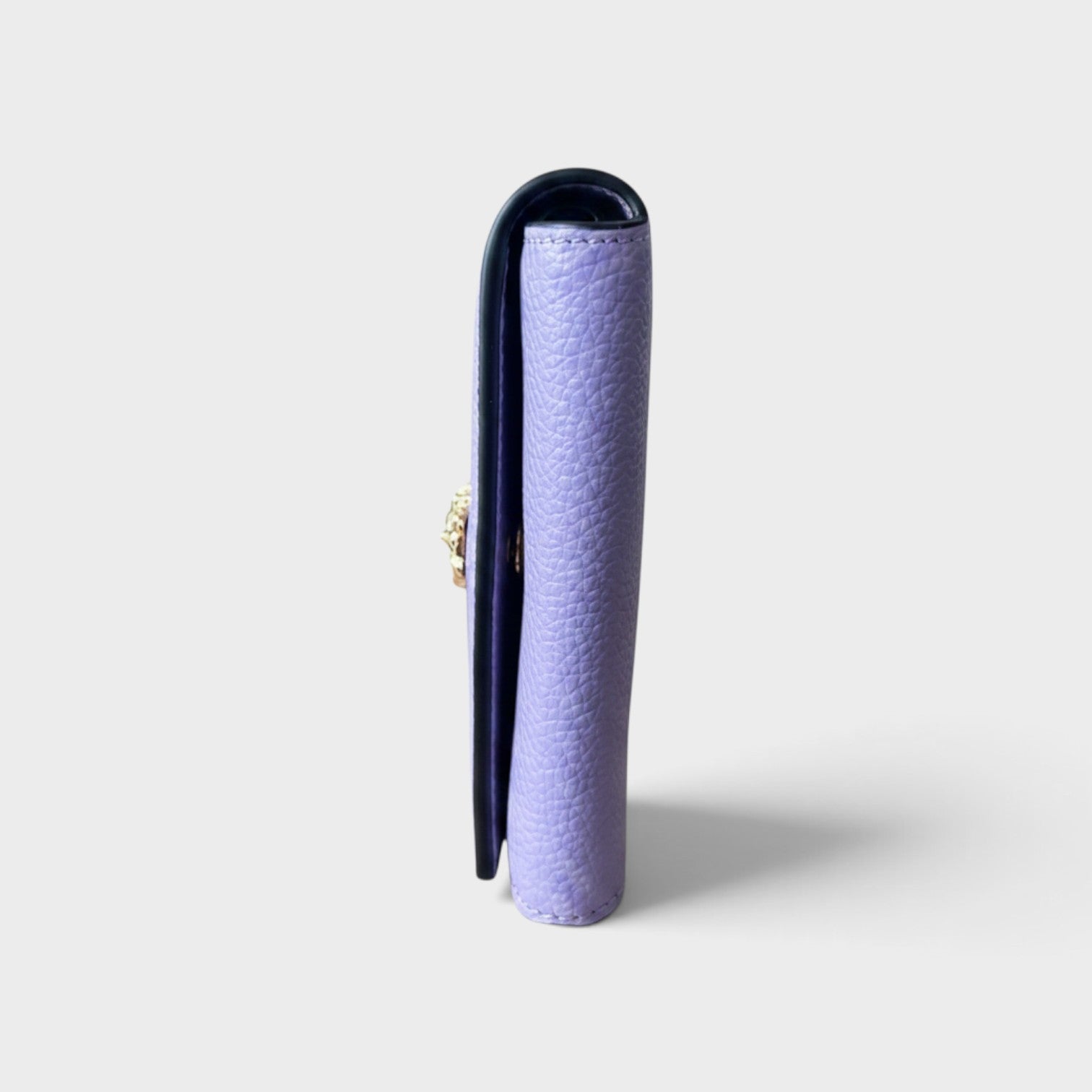 Supplied Fashion purple leather business card holder with a gold Medusa head motif, side profile view.