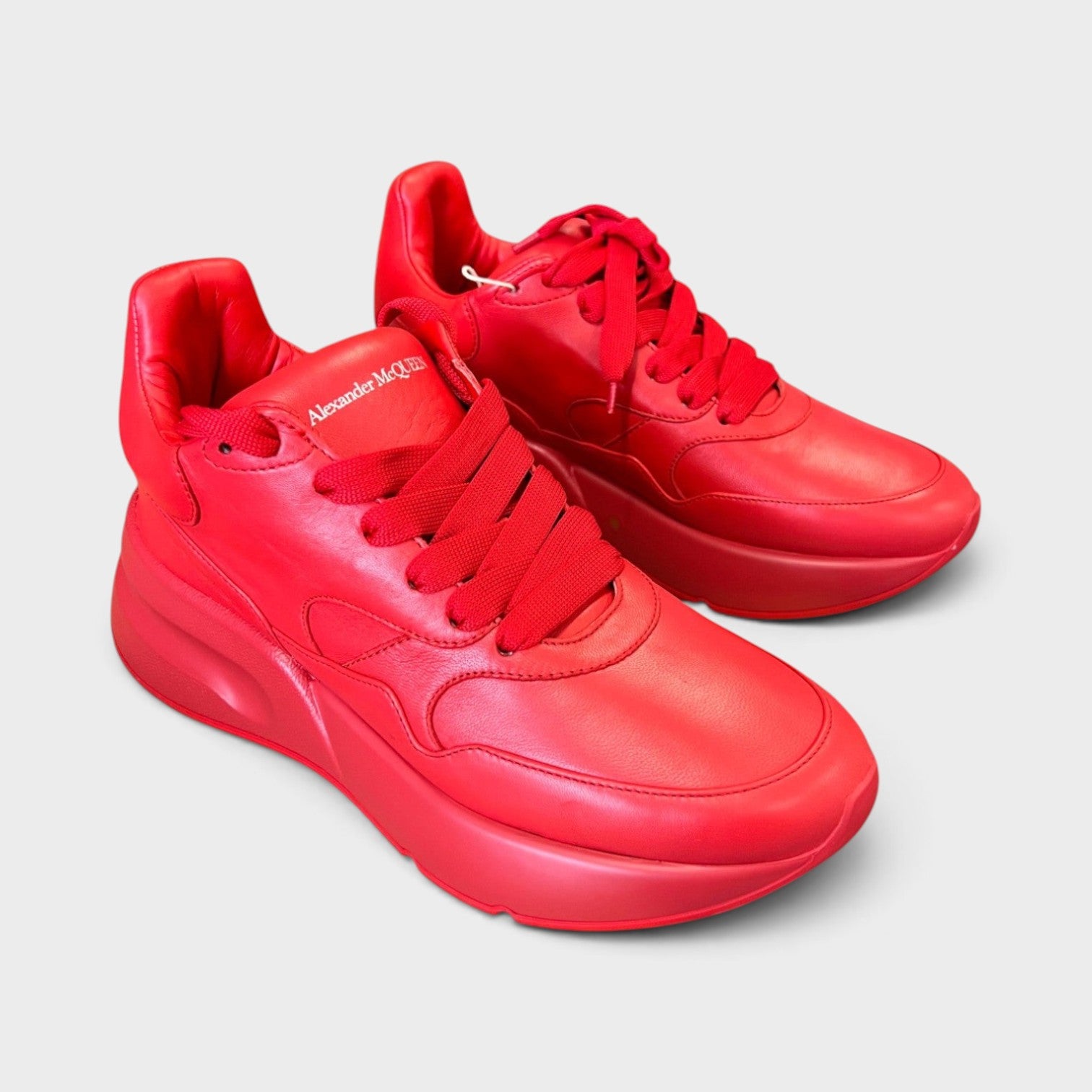 Supplied Fashion Alexander McQueen red leather oversized runner sneakers with thick platform soles and lace-up closure.